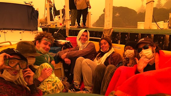 Ryley Gray, Conor Eivers, Marco Cussigh, Lauren Martin, Jazz Fairbrother and Nick Roberts shelter in a boat in Mallacoota.