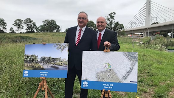 Liberal MPs Brad Hazzard and David Elliott stand on the newly acquired land where the Rouse Hill Hospital will be built.
