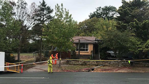 Crews wearing gas masks and protective gear are seen entering the home in Mawson where the clandestine lab was allegedly set up.