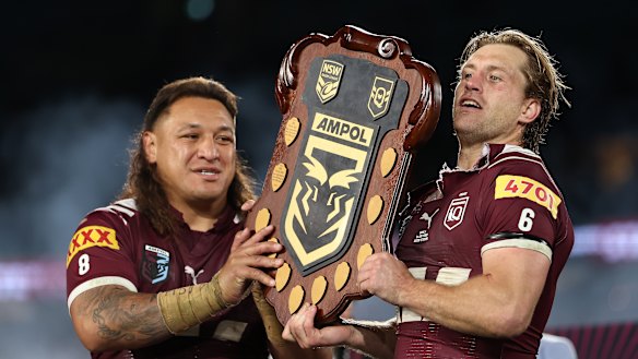 Cameron Munster and Josh Papali’i celebrate Queensland’s series win with the Origin shield.