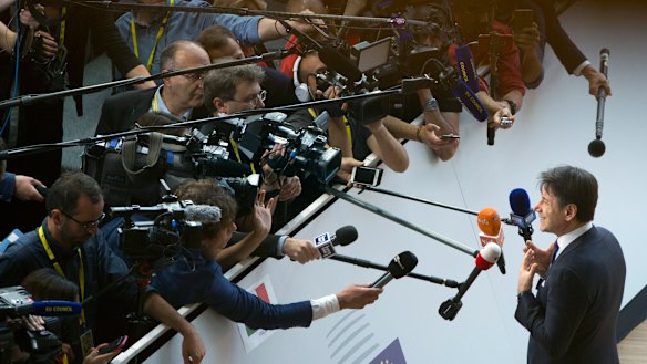 Italian Prime Minister Giuseppe Conte speaks with the media as he arrives for an EU summit in Brussels.