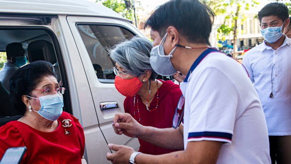Ferdinand “Bongbong” Marcos jnr speaks to his mother Imelda after casting his vote at the Mariano Marcos Memorial Elementary school in Batac, Ilocos Norte.