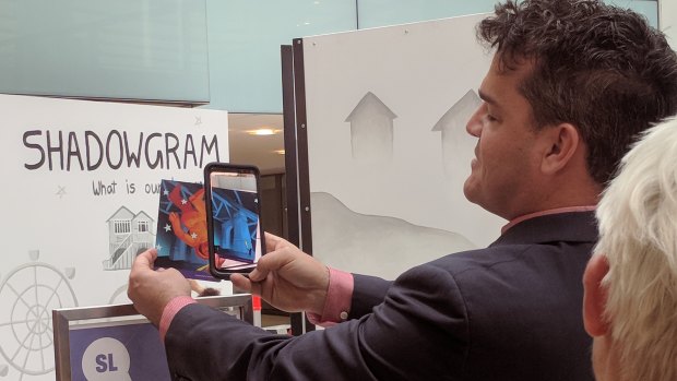 Brisbane Powerhouse artistic director Kris Stewart demonstrating the augmented reality aspect of the Shadowgram installation ahead of Curiocity Brisbane.