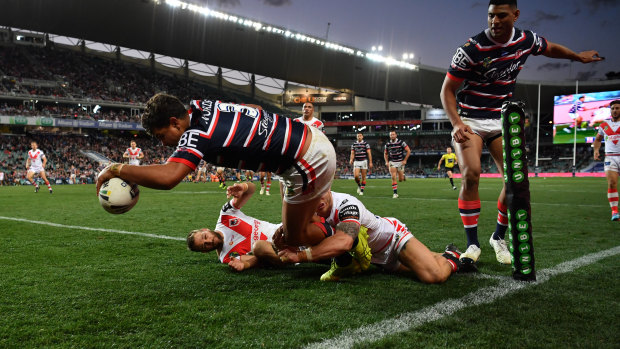 Star turn: Latrell Mitchell scores out wide for the Roosters.