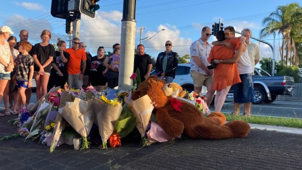 Locals gather at the intersection for a vigil on Thursday afternoon.