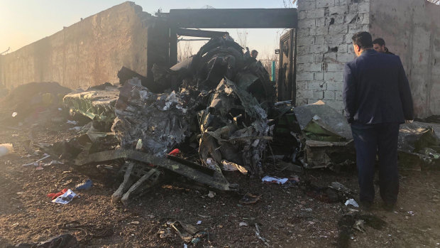 People inspect debris from the Ukrainian Airlines plane on the outskirts of Tehran. 