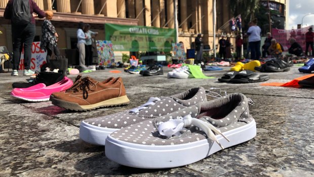 Hundreds of pairs of children’s shoes laid out outside City Hall for an Extinction Rebellion protest