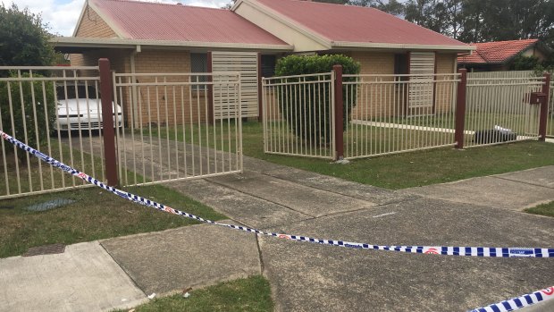 Police cars line the streets outside the home on Waratah Drive at Crestmead.