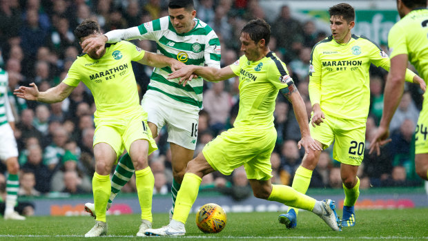 Happy Hibee: Mark Milligan puts in a challenge on Socceroos teammate Tom Rogic while playing for Hibs against Celtic.