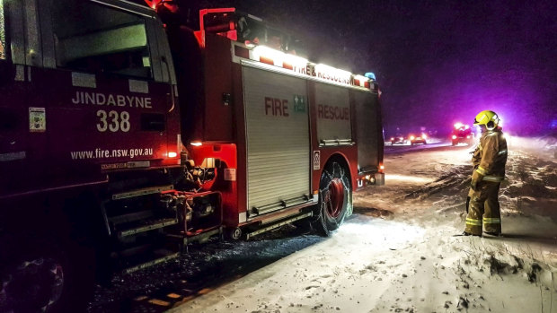 A Fire and Rescue NSW team responding to a road accident in the snow after helping with the Bega bushfires earlier in the day.