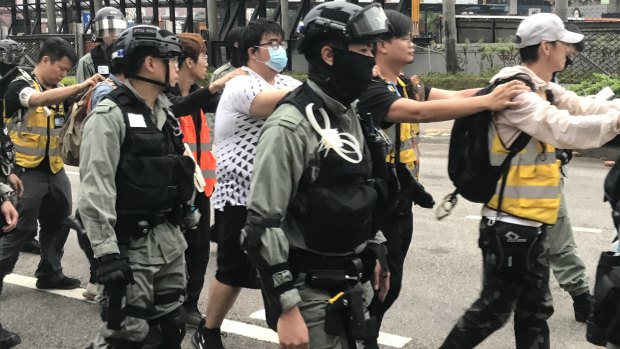 People wearing the yellow vests of volunteer group Save the Children among those arrested in Hong Kong.