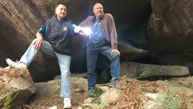 Geocachers Greg Shaw and Thomas Schulze emerge from the ‘secret’ cave in Pierces Creek Forest.