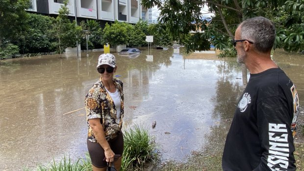 Jason and Rebecca Petzke look at cars swamped by floodwater at West End in 2021.