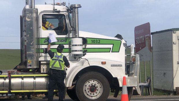 Police check a truck driver's permit on the Victoria-South Australia border last month. 
