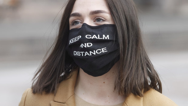 A young woman in Ukraine asks people to “keep calm and distance” with her cloth mask.