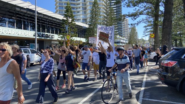 Protesters marched down the Esplanade at Coolangatta before congregating at the NSW border on Sunday