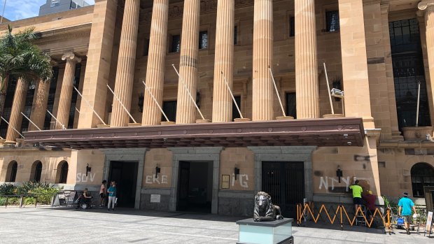 The hours-long removal of the white paint from the front of Brisbane City Hall starts.