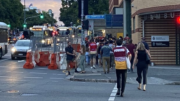 Broncos and Dolphins fans walk along Roma Street to climb the stairs to Caxton Street for a game at Suncorp Stadium.