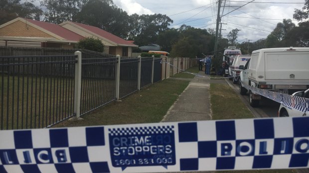 Police cars line the streets outside the home on Waratah Drive at Crestmead.