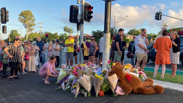 Locals gather for a community vigil at the Alexandra Hills intersection, the day after the crash.