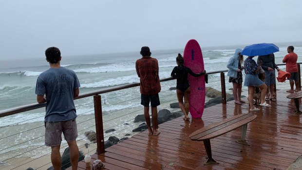 The inclement conditions failed to deter some beachgoers and surfers at Snapper Rocks on the Gold Coast on Monday.