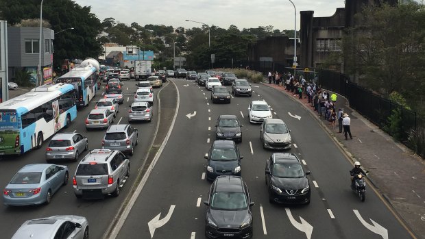 Traffic is banked up and passengers wait for buses on Victoria Road due to the ongoing police operation on the Harbour Bridge.