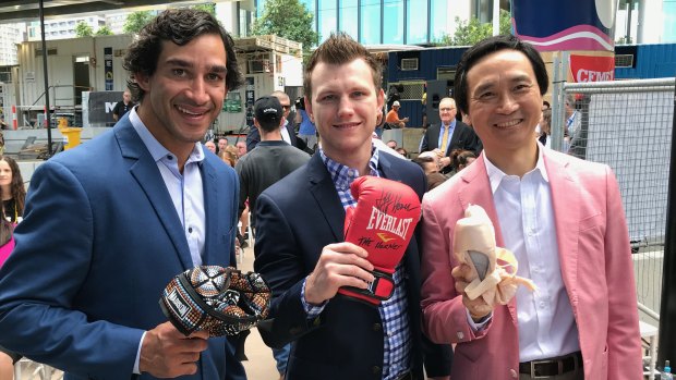 Rugby league star Jonathan Thurston with his indigenous allstars headgear, world welterweight boxing champion Jeff Horn with a signed boxing glove and Chinese born ballet star of Mao's Last Dancer Li Cunxin with some ballet shoes. All items are inside a time capsule buried in Queens Wharf Brisbane.