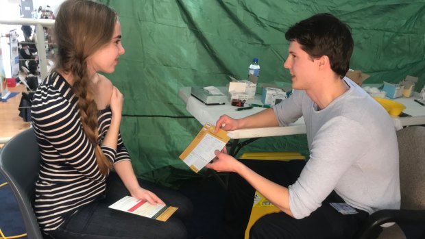ANU student Brianna Eggleton, 19, receives a free meningococcal vaccine from ACT health registered nurse Jackson Taylor.