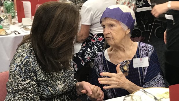 Premier Annastacia Palaszczuk holds hands with 100-year-old family friend Yadja Cartmer at a pre-Christmas function for Queensland's 100 Club.