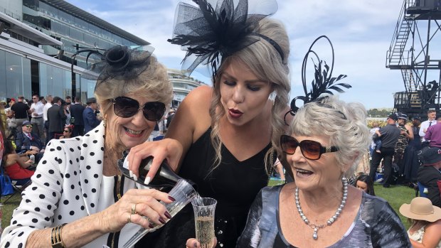 Alex Whelan, from Sydney, pours champagne for Lyn Hyland and Jenny Hobson, from Port Stephens.