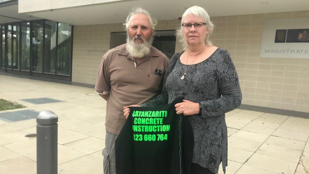 Kay Catanzariti, pictured with her husband Barney and holding the jumper her son Ben was wearing when he died on a construction site on the Kingston foreshore.