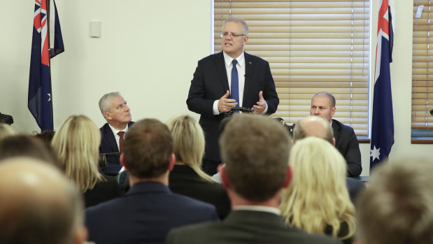 Scott Morrison, flanked by Deputy Prime Minister Michael McCormack and Treasurer Josh Frydenberg, addresses the party room.