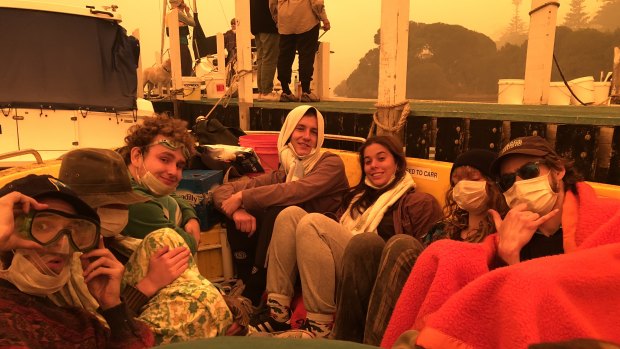 Ryley Gray, Conor Eivers, Marco Cussigh, Lauren Martin, Jazz Fairbrother and Nick Roberts shelter in a boat in Mallacoota.