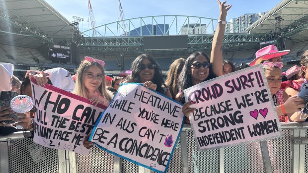 Manekha Balgobin with friends holding signs up for Harry Styles to read.
