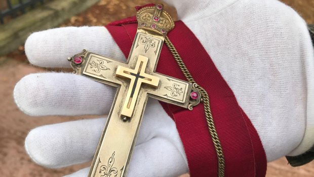 Canon David Garland's gold cross, given to him when he was in Jerusalem in 1920, containing splinters from the cross on which Jesus was crucified, according to Christians. Canon Garland began the Anzac Day service tradition in Brisbane.