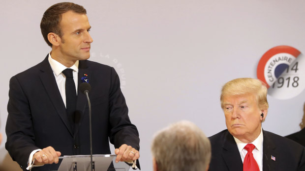 Macron delivering a speech while Trump looks on before a lunch at the Elysee Palace on Sunday.