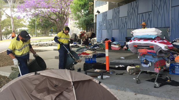 Brisbane City Council workers clear a homeless 'township' under the Go Between Bridge in October 2016.