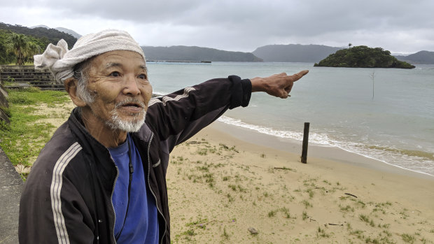 Japanese elder Kinsei Ishigaki points to the crash site off the coast of Sonai, Iriomote Jima.