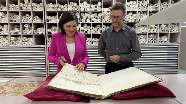 Queensland Digital Economy Minister Leeanne Enoch inspects plans of old buildings protected by heritage buildings legislation with political historian Dr Chris Salisbury at the Queensland State Archives.