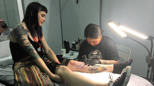 A woman sits for a new tattoo at the Australian Tattoo Expo at the Brisbane Convention Centre on Sunday.