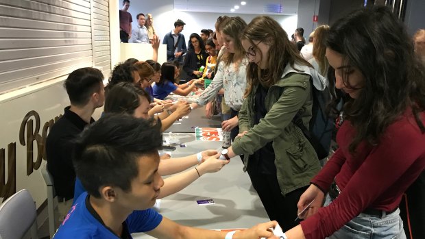 Students receive identification before casting their votes at UQ.