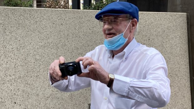 William “Billy” Stokes greets the media cameras with one of his own as he leaves Brisbane Magistrates Court on Wednesday, saying “your turn” to those photographing him.