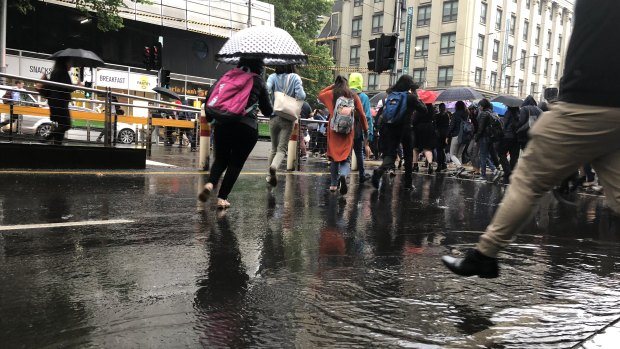 Commuters avoid puddles in the city on Thursday morning. 