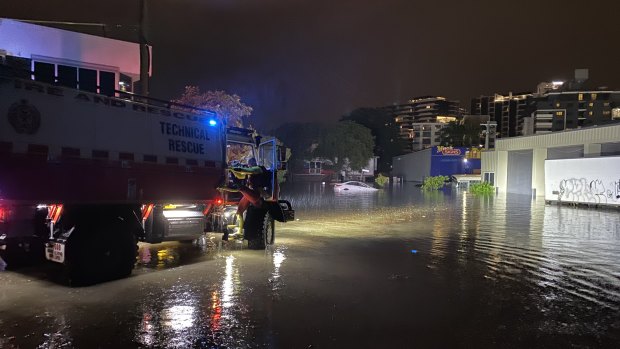 Swift water rescue crews check a floating car in Lotus Street, Woolloongabba last night to ensure nobody is inside.