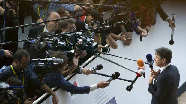 Italian Prime Minister Giuseppe Conte speaks with the media as he arrives for an EU summit in Brussels.