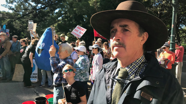 Galilee Basin cattle farmer Bruce Currie protests outside Queensland's Parliament House as scientists evaluate Adani's Carmichael mine groundwater study.