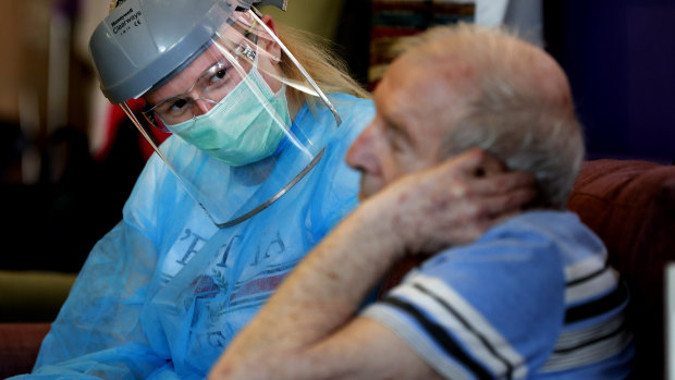 A nurse speaks to a resident at a care home in England. 