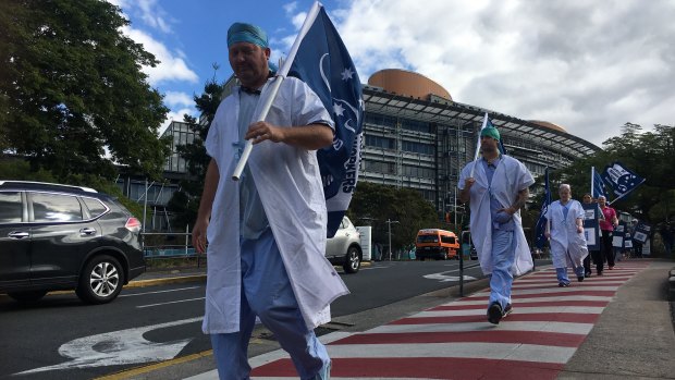 Workers strike outside Brisbane's Princess Alexandra Hospital on Friday afternoon over the state government’s planned public service wage freeze