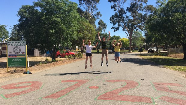 East Loddon P-12 College students Jess Demeo, Stephen Verley and Macey Martin jump for joy on VCE results day in 2019. Dux Stephen Verley's ATAR was spraypainted onto the school's driveway and is still visible to this day. 