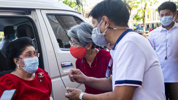 Ferdinand “Bongbong” Marcos jnr speaks to his mother Imelda after casting his vote at the Mariano Marcos Memorial Elementary school in Batac, Ilocos Norte.